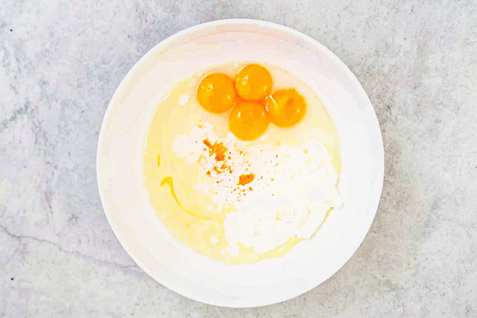 Ingredients for making a 4-ingredient cloud cake Ingredients for cloud cake with eggs and condensed milk in a bowl