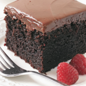Chocolate Cake – Moist, Rich & Easy Homemade Recipe Chocolate Cake Thick slice of moist chocolate cake with creamy frosting and fresh raspberries